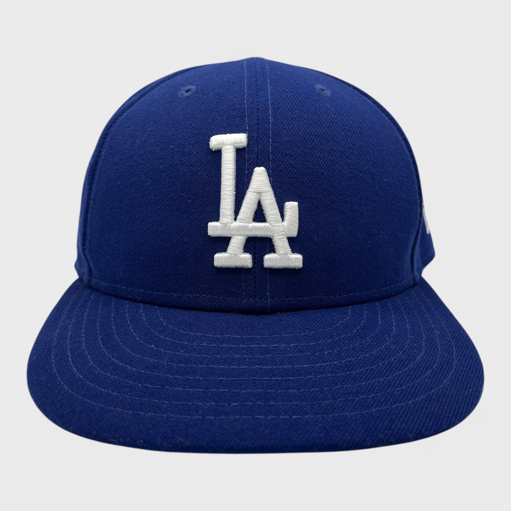 Blue Dodgers baseball cap with white LA logo on a light gray background