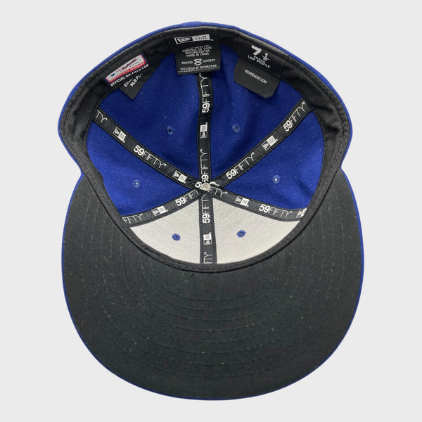 Baseball cap with blue interior and black exterior on a light gray background