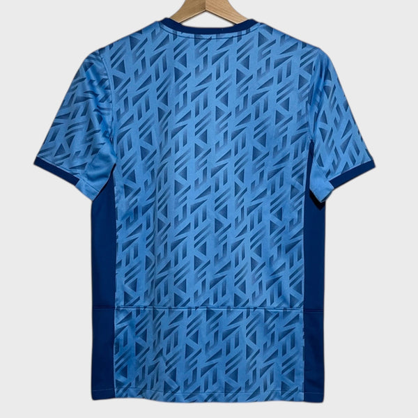 Blue geometric patterned soccer jersey on a hanger against a white background