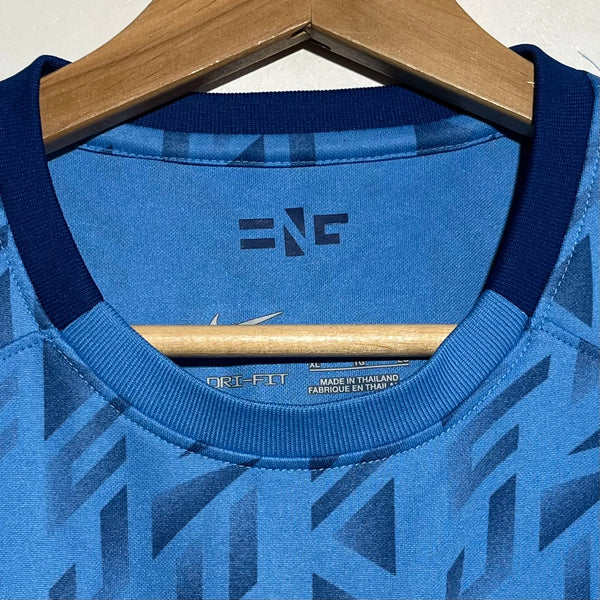Blue soccer jersey collar with geometric pattern on a hanger