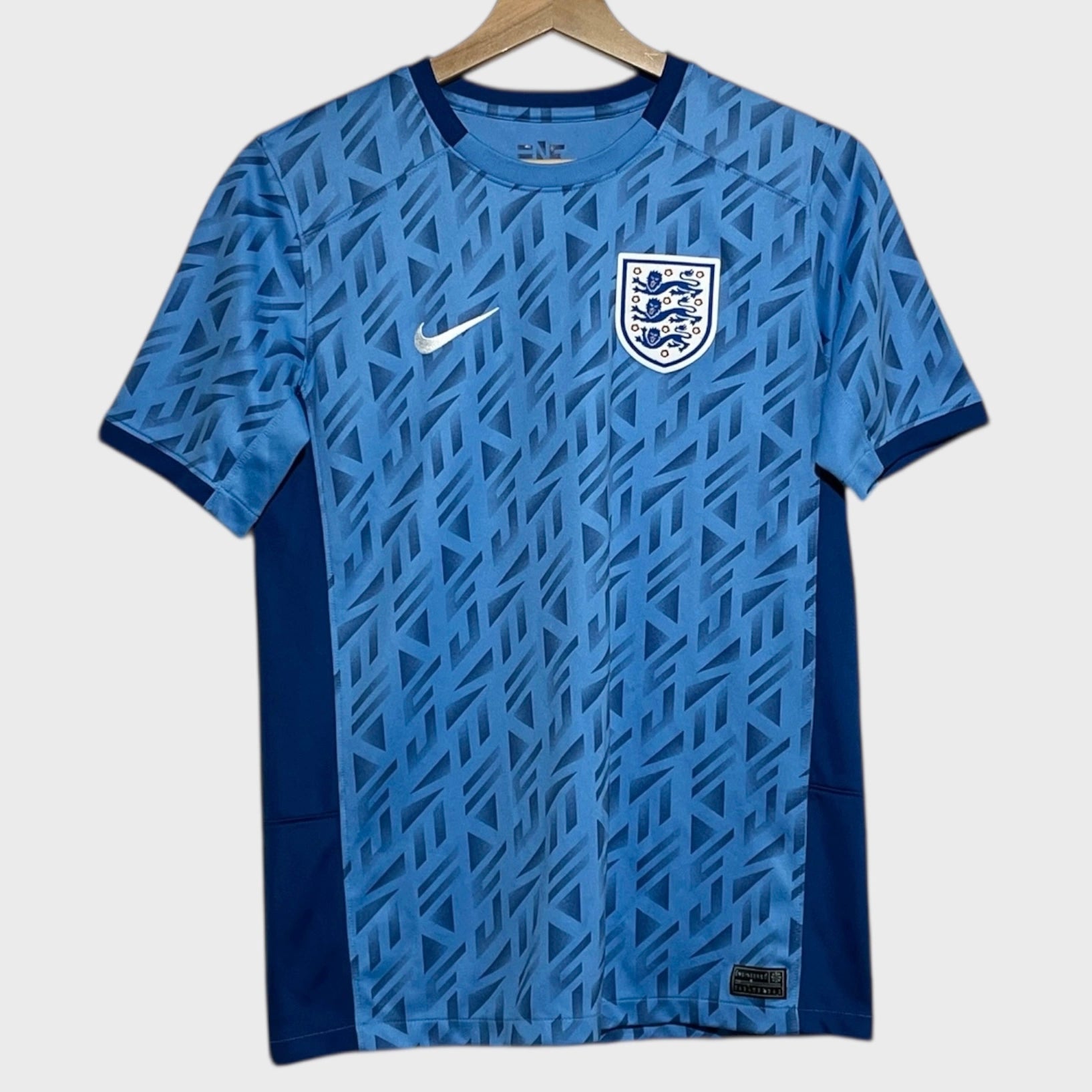Blue soccer jersey with Nike logo and England flag on a white background