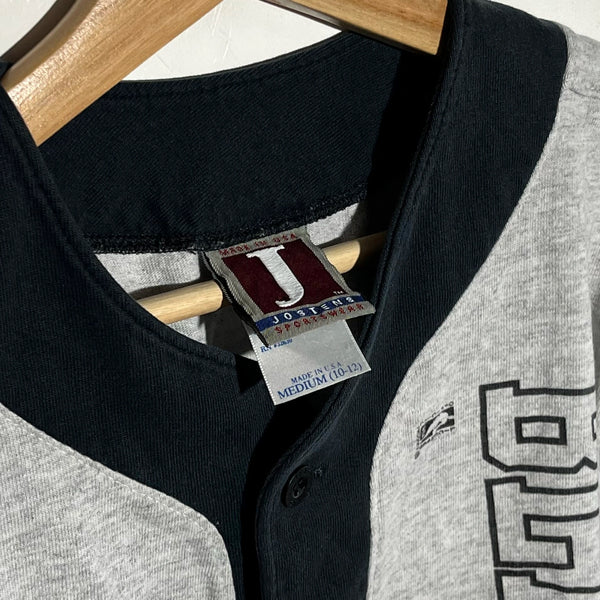 Black and gray baseball jersey collar with a brand tag on a wooden hanger