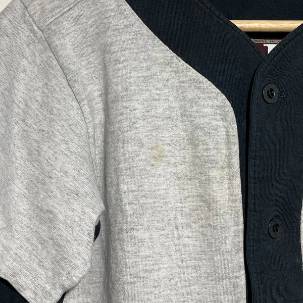 Gray and black baseball jersey with a visible stain on the gray sleeve.