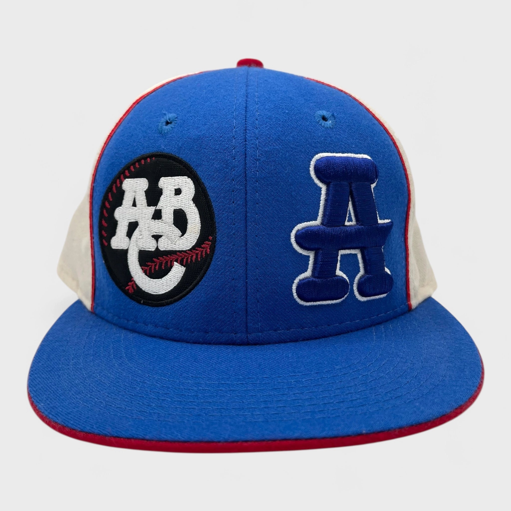 Blue and white baseball cap with logos on a light gray background