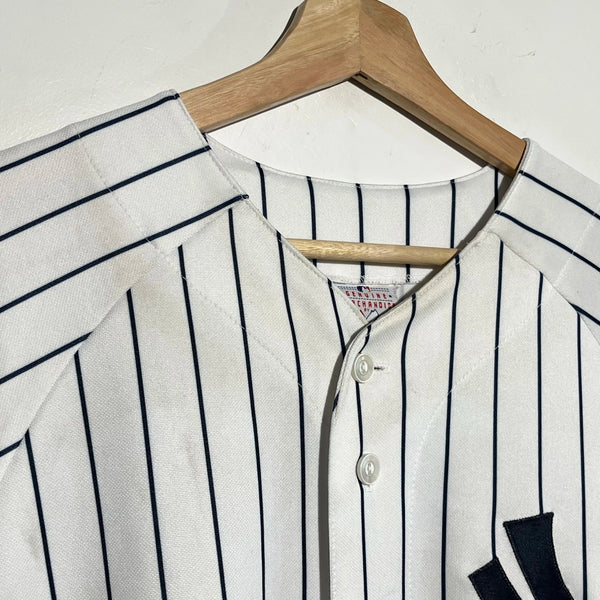 White baseball jersey with black pinstripes on a wooden hanger against a white background
