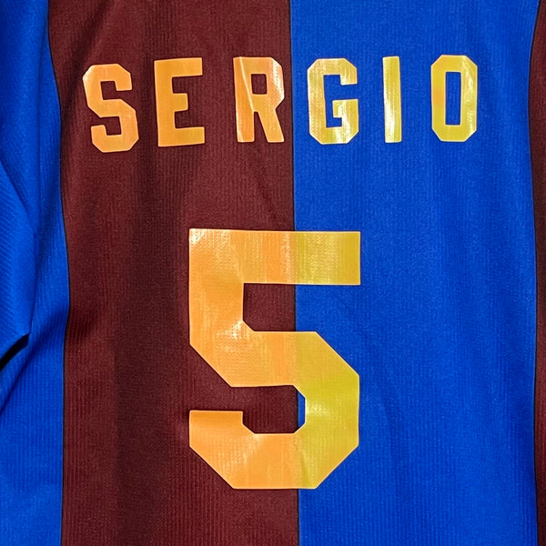 Close-up of a sports jersey with 'SERGIO' and number '5' in gold on a red and blue background.
