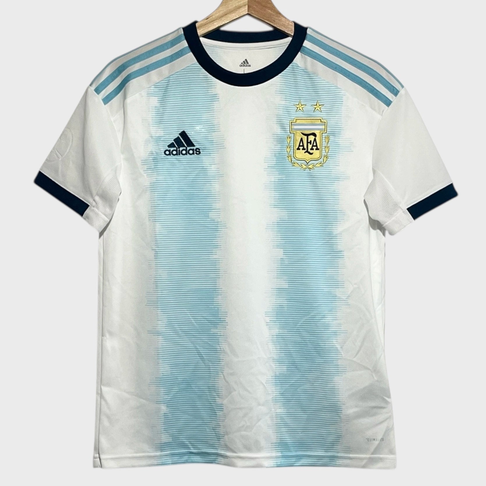 White and blue striped soccer jersey with Adidas logo on a hanger