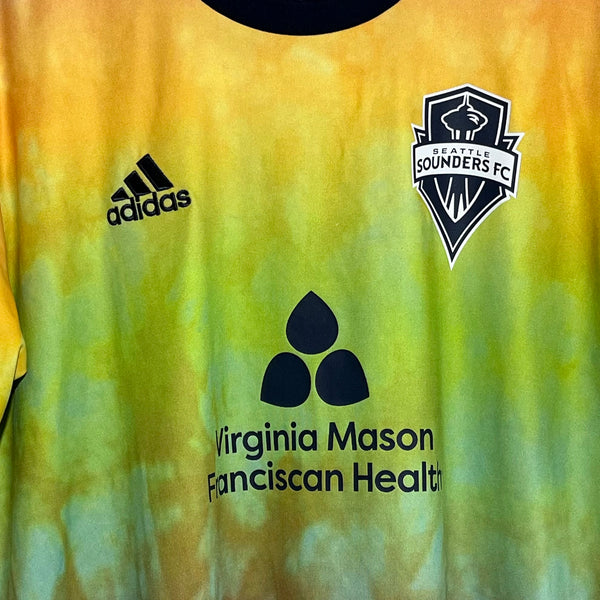 Soccer jersey with Adidas, Sounders FC, and Virginia Mason Fanciscan Health logos on a yellow and green background.